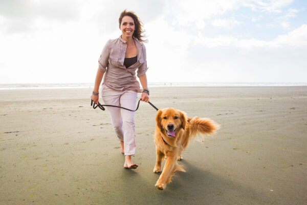 lady-walking-on-beach-wiht-dog-pain-free